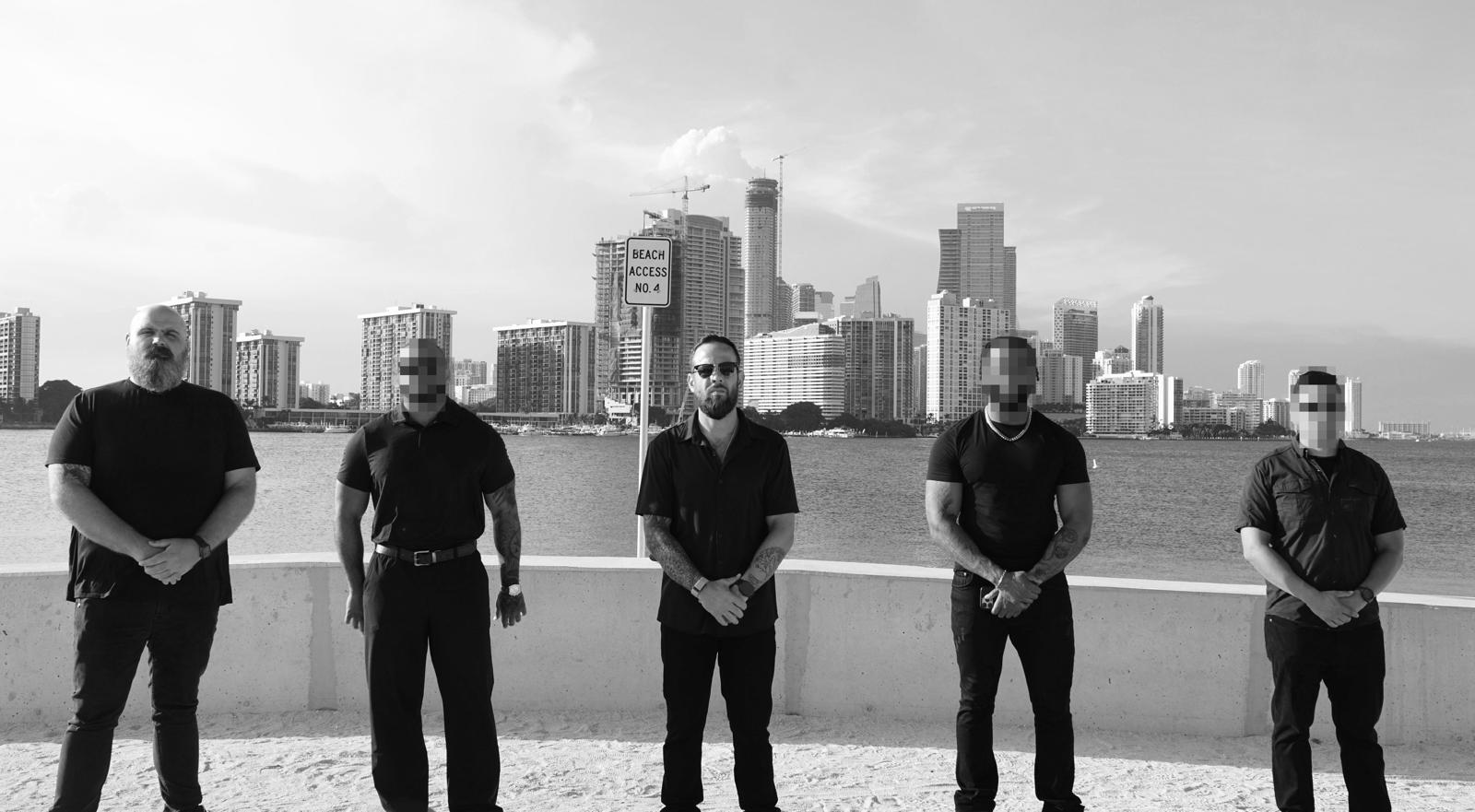 Broward Private Investigations team at Biscayne Bay with the Miami skyline behind them