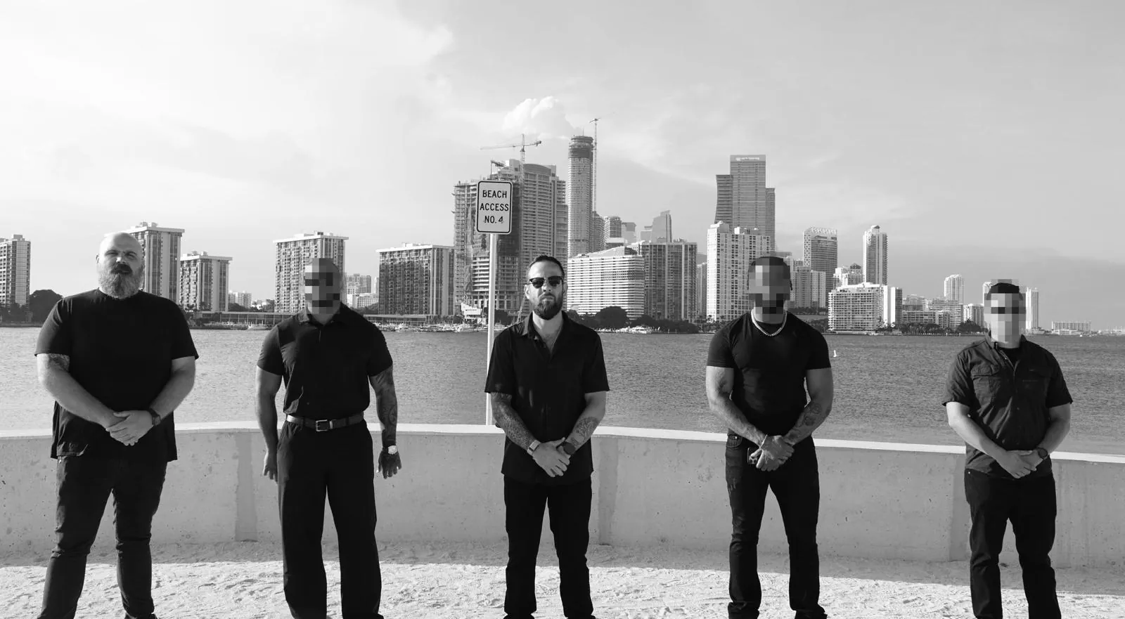 Broward Private Investigations team at Biscayne Bay with the Miami skyline behind them